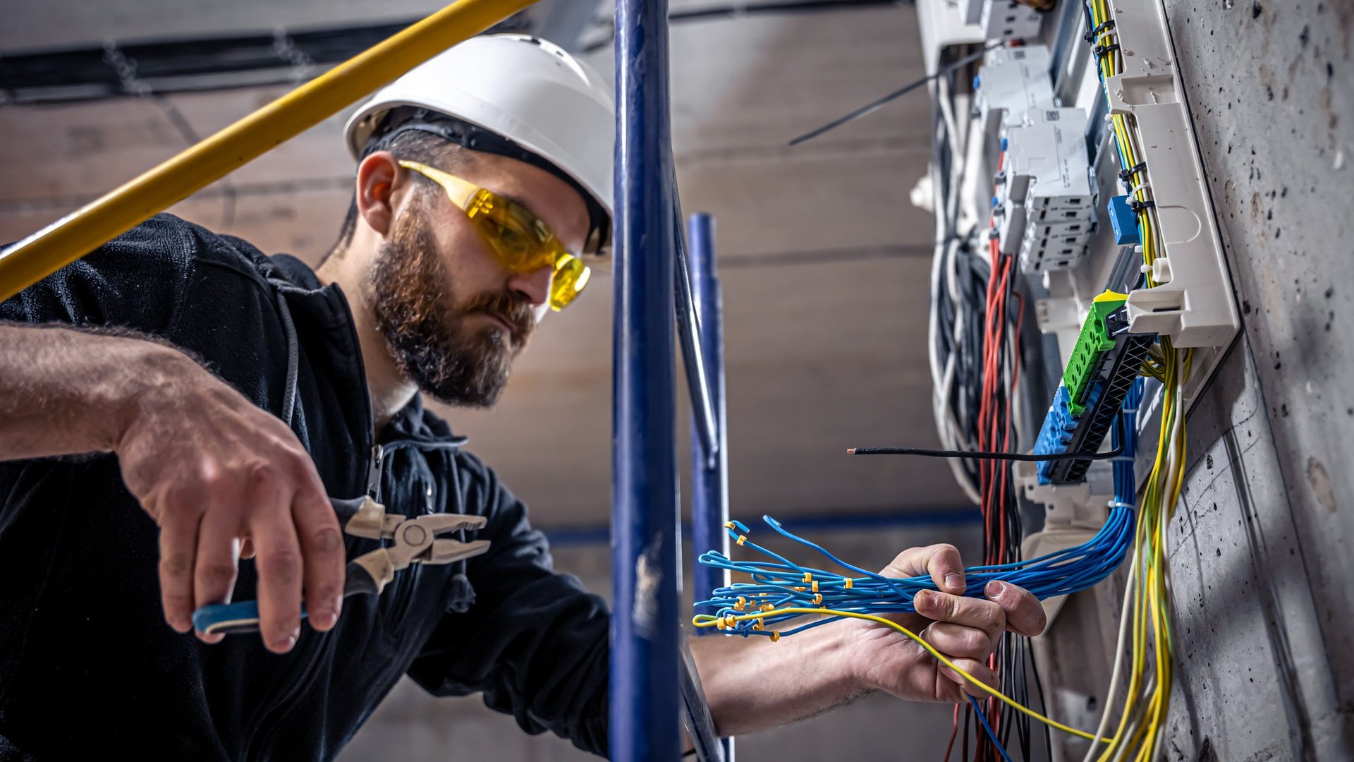 An electrician working on an electrical panel
