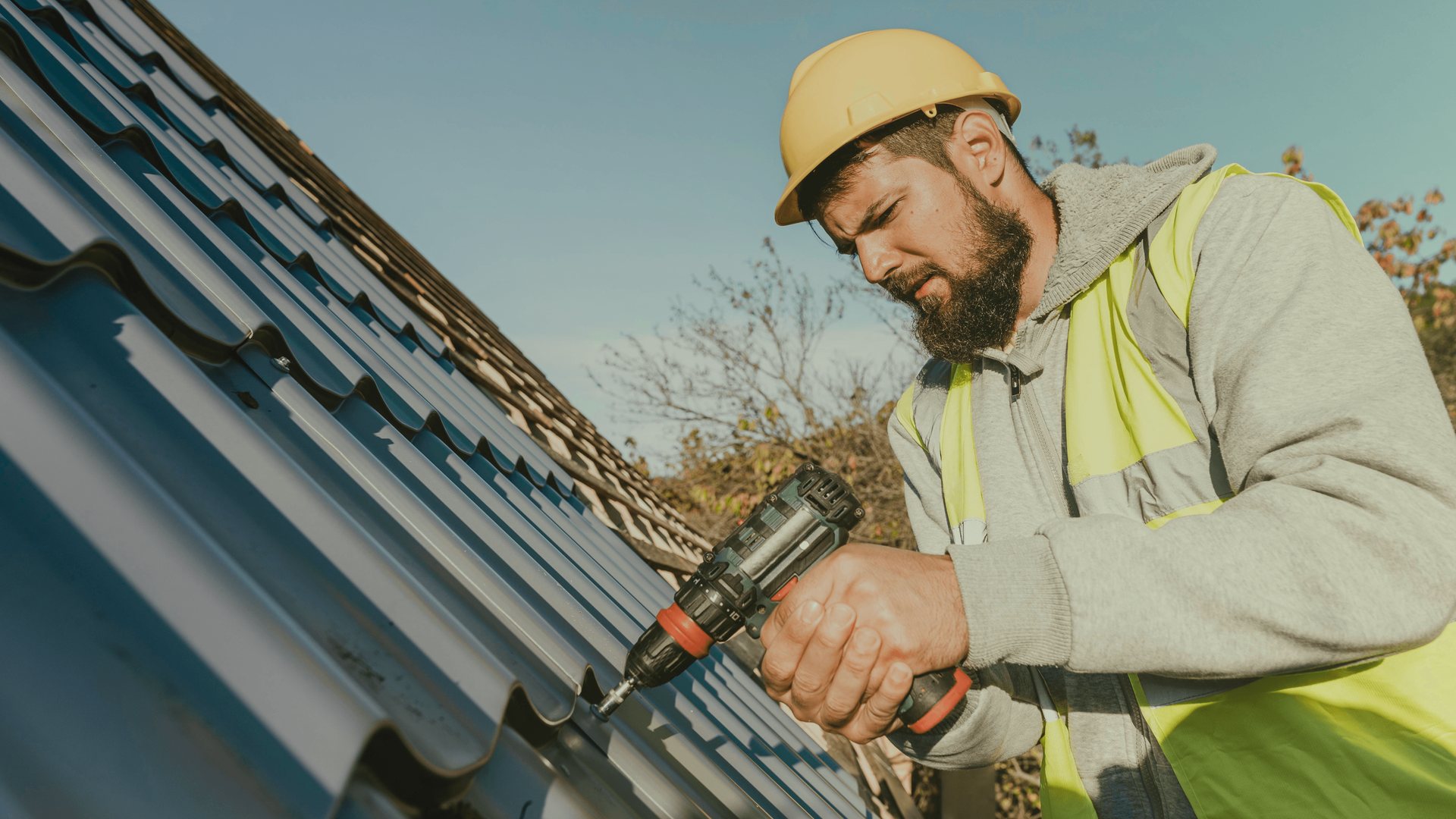 A roofer working on a shingle roof